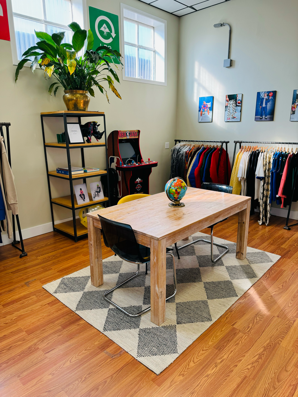 Wild Thing$ standalone showroom in Louisville, Kentucky featuring curated apparel racks, a wooden table for design sessions, and a space that blends fashion, culture, and community.